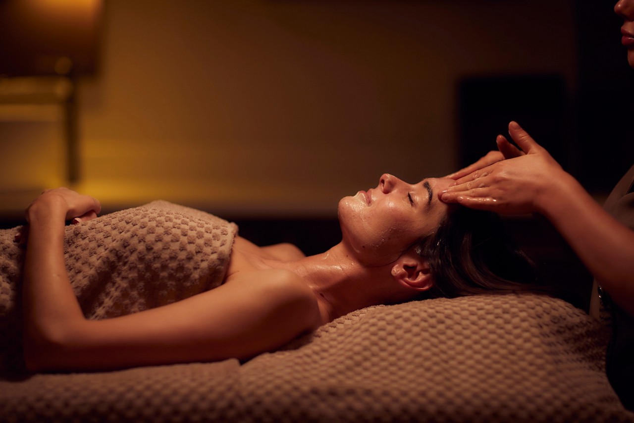 Spa therapist giving a woman a facial treatment.